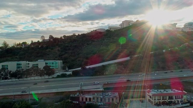 Getty Center building by empty 405-Freeway during Coronavirus Covid-19 in Los Angeles, California. Sun flare aerial drone shot during sunset
