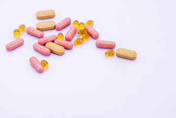 Multi-colored pills on a light background. Omega-z, pink and yellow capsules with medicines.