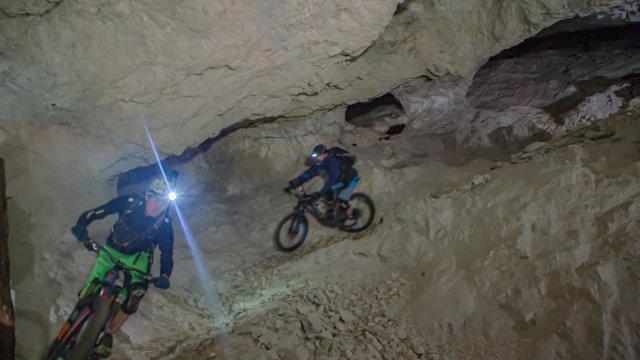 Mountain bikers in underground cave in Prevalje, Slovenia