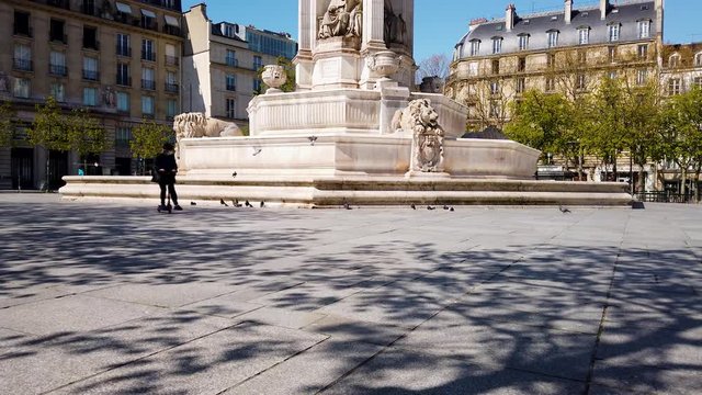 Quiet square in Paris with old monument in center of classic Architecture buildings during confinement from Coronavirus 