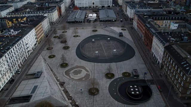Drone flying slowly over a square in Copenhagen with basketball courts and a foodmarket. No people due to Corona virus lock-down.