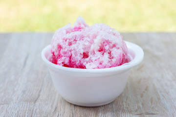 Shave ice in a white foam cup on wooden table, Sweets suitable for summer.