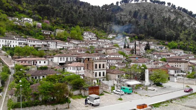 Medieval architecture of Otoman era with white houses on slope of mountain with pine trees in Gorica neighborhood in Berat, Albania