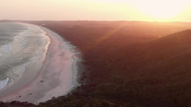 Golden sunset flying over Cape Byron Bay beach, NSW Australia