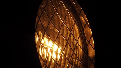 Close up of a yellow light reflector turning off slowly to the darkness