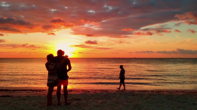 Silhouette of couple in love at sea in golden and beautiful sunset. Young romantic couple enjoying the sunset in Cuba.