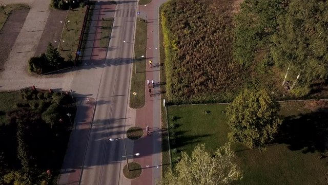 Aerial following a group of cyclists riding bikes on Goldap town, Poland