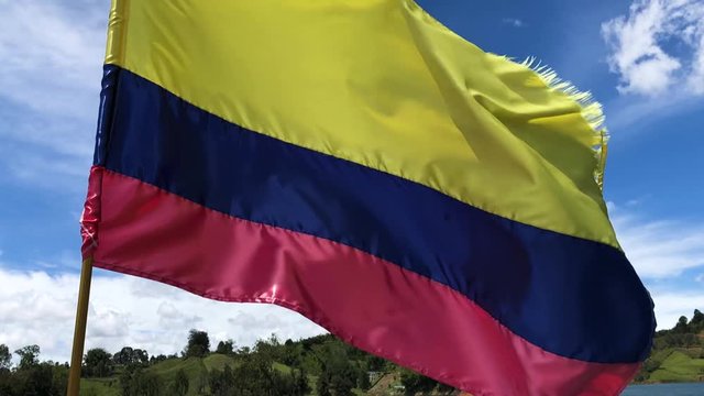 Colombian flag waving in slow motion in a sunny day. Close up shot of Colombian flag, waving in a blue sky. Bandera de Colombia ondeando en camara lenta.