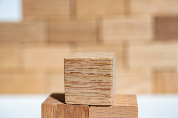 Wooden block cubes stacked in a pyramid in front of a defocused block wall