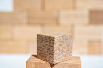 Wooden block cubes stacked in a pyramid in front of a defocused block wall