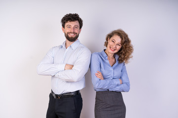 The guy and the girl looks directly at the camera, stand side by side, smiling, cheerful, business