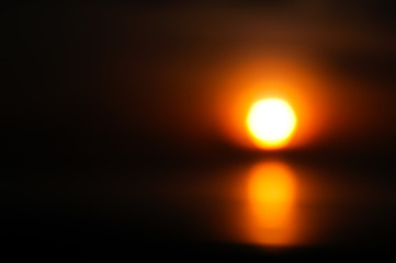 Abstract blur background of sunset The beach at sunset is blurry with bokeh light. Copy the area of ​​the outdoor summer. Orange and black filter style. Sunset background.