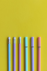 L&aacute;pices y marcadores sobre fondo color amarillo