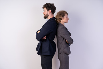 business man and woman standing shoulder to shoulder in suits on a white background, strong