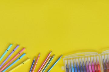 Colores y marcadores de colores sobre fondo amarillo
