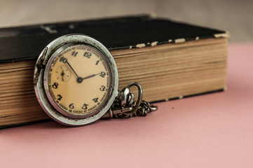 Closeup old vintage book and a pocket watch with copy space
