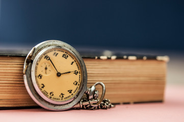 Closeup old vintage book and a pocket watch with copy space