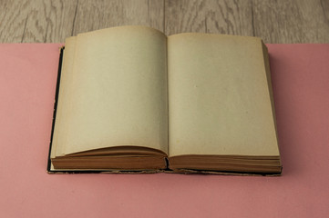 Aged blank book on wooden table, blank pages. Top view