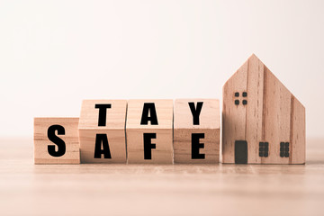Flipping wooden blocks change wording stay and safe with wooden home. Stay home to prevent COVID 19...