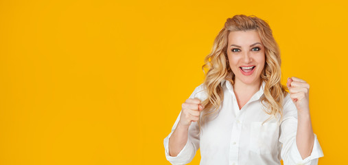 Cheerful, happy woman raising her hands with her fist, cheering for the team, winning a huge bet, playing in the casino in delight