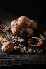 Walnuts on a very old board. Dark food photo.