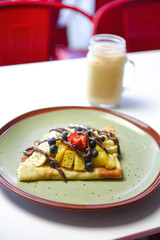 breakfast crepe with bananas and blueberries and pineapple