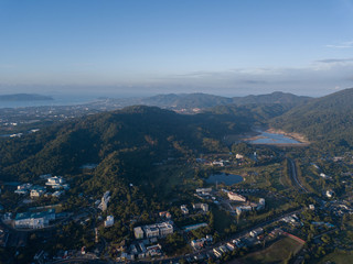 Beautiful lake located on a golf course surrounded by houses and mountains at dawn, photo from a drone. In the lake the reflection of the sky. Great background for travel and golf advertising.