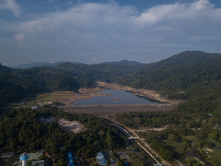 Fototapeta na wymiar A dry dam due to the lack of rain in Thailand. Beautiful lake at sunrise located between the hills and golf courses