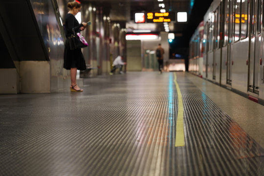 Low angle and selected focus view at yellow tape line lie in front of tram on platform underground railway station in Germany during social distancing by epidemic of COVID-19.
