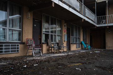 old abandoned motel with chairs in the front and dirty and vandalized environment