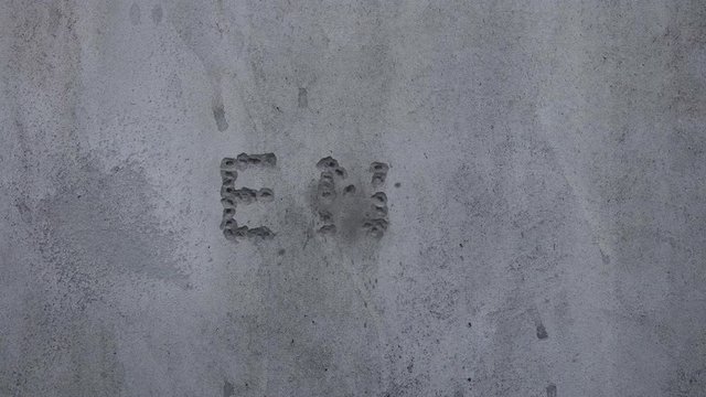 Bullet hits in a concrete wall, spelling out the word "END".