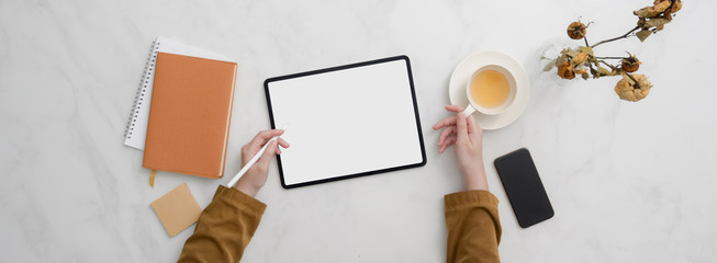 Top view of college student doing homework with mock-up tablet on marble desk