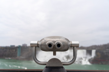 Tourist Binoculars for sightseeing in Niagara Falls, Canada viewing a majestic waterfall during the cloudy sky 