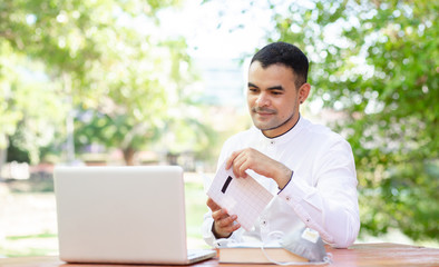 Wear a protective mask to prevent disease,young asian business man, work from home,In the back of the house to be happy