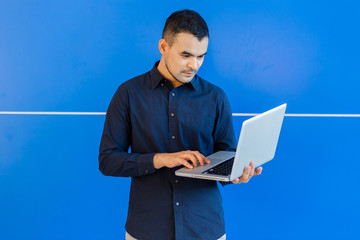 young asian business man, Happy young man working on laptop,at his working from home,Mock up copy space,On a blue background