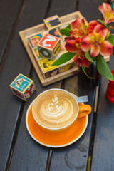 Cup of flat white coffee in colorful mug on a cafe table 