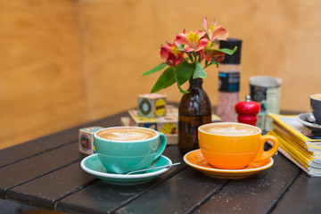 Cups of coffee in colorful mugs on a cafe table 