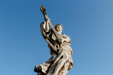 Statue of Angel Holding Cross on bridge near st peter basilica rome italy