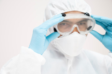 Portrait Asian doctor in protective PPE suit wearing face mask and eyeglasses for protect coronavirus covid-19 virus.Scientist male wearing personal protection equipment making laboratory in hospital.