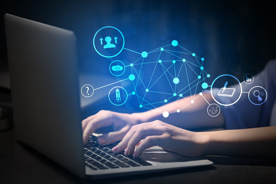 Woman working on laptop at table in evening, closeup
