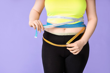 Overweight woman with measuring tape on color background. Weight loss concept