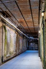 Alcatraz Prison old hallway inside the barracks apartment with rusty walls, ceiling grills and pipes