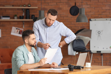Mentor teaching young photographer in studio