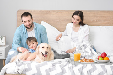 Happy family having breakfast in bedroom