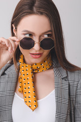 Beautiful young woman with stylish scarf on grey background