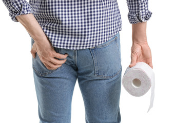 Young man suffering from hemorrhoids on white background