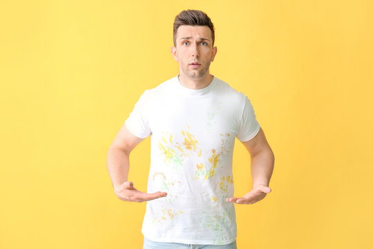 Troubled man in dirty clothes on color background