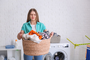 Troubled woman doing laundry in bathroom
