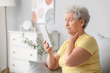 Elderly woman video chatting with doctor at home