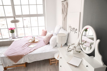 Interior of beautiful modern bedroom with spring flowers